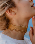 ragazza indossa collana girocollo choker argento nastro passamaneria onde giallo oro made in italy