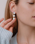 ragazza indossa orecchini pendenti argento tre bottoncini madreperla bianca made in italy